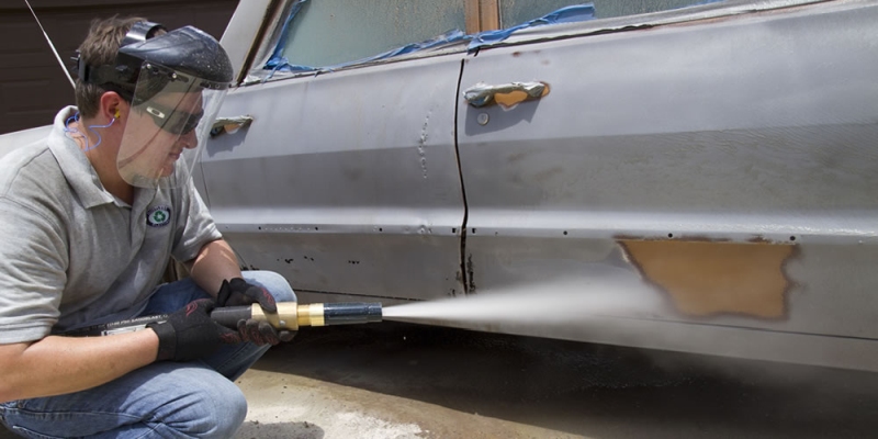 Stripping paint from a car with sand blasting