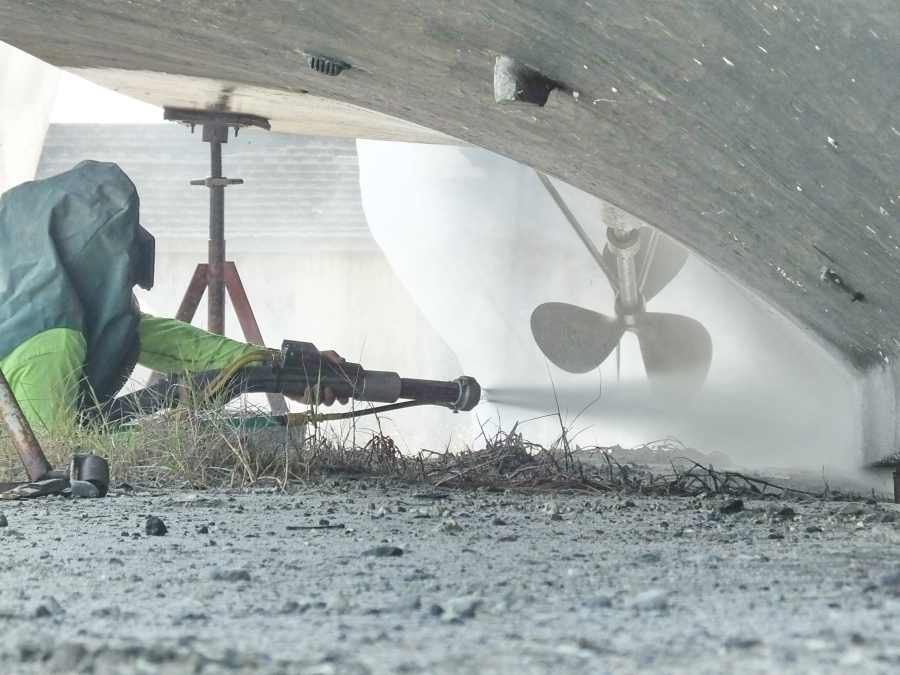 Wet Sand  Blasting a yacht