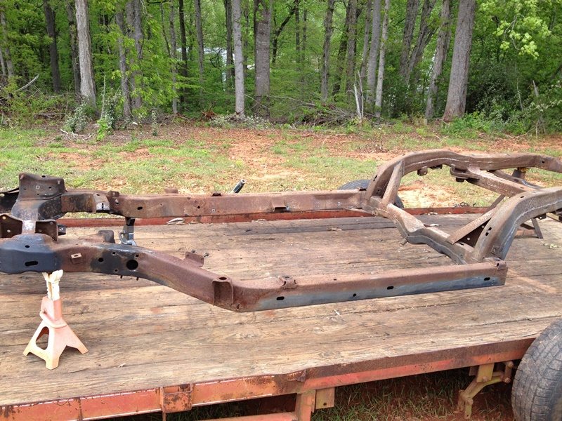 Sand blasting vehicle frames in a gravel parking lot. 