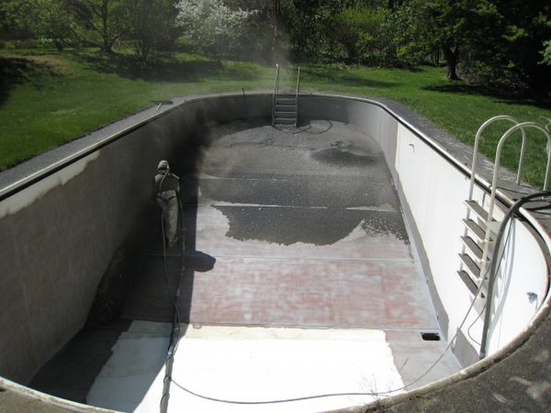 Stripping a swimming pool of the old fading paint.